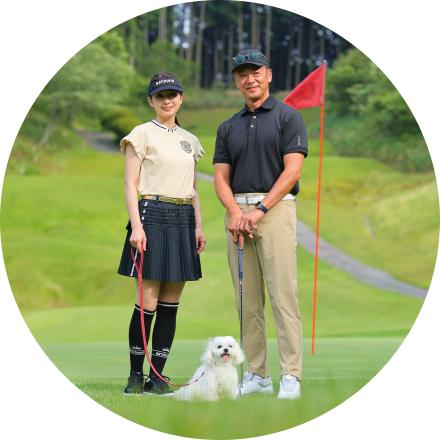 ゴルフ姿の男女とワンちゃんの写真