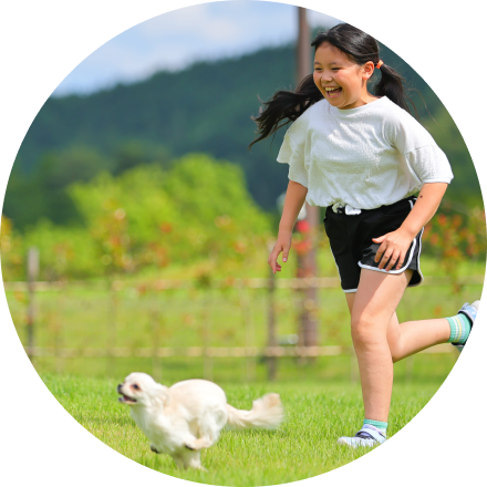 女の子とワンちゃんが走っている写真